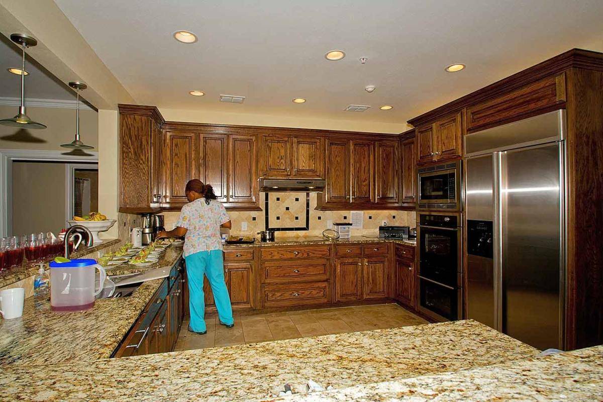 A spacious kitchen with wooden cabinets and granite countertops, featuring modern appliances.