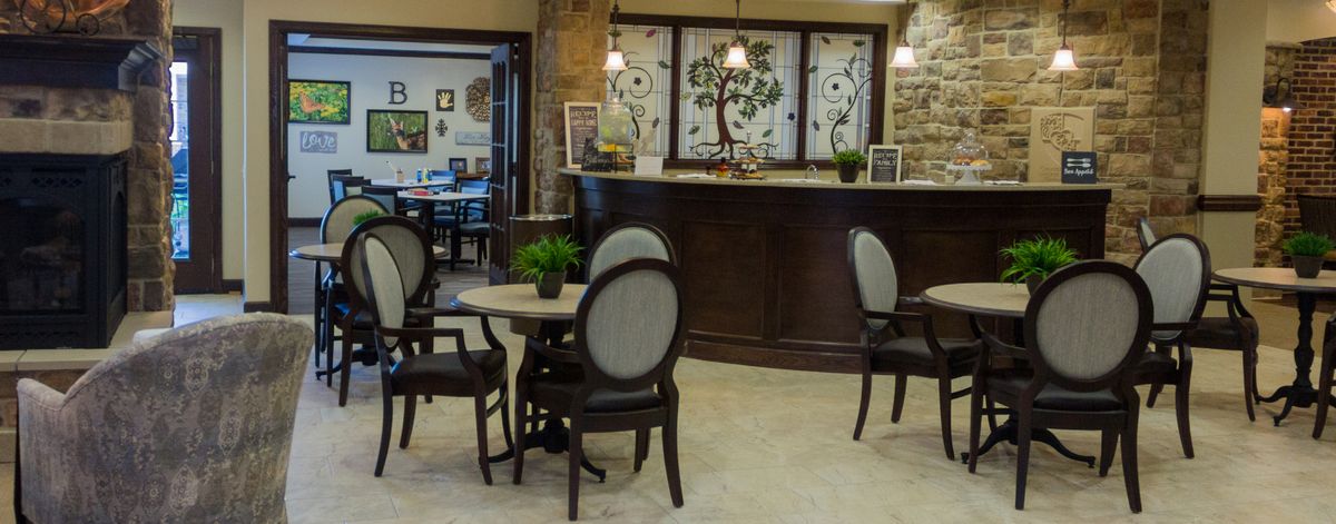 A cozy seating area with elegant furniture and a reception desk featuring stained glass decor.