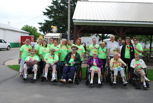 A joyful gathering of seniors and caregivers enjoying a community event together.