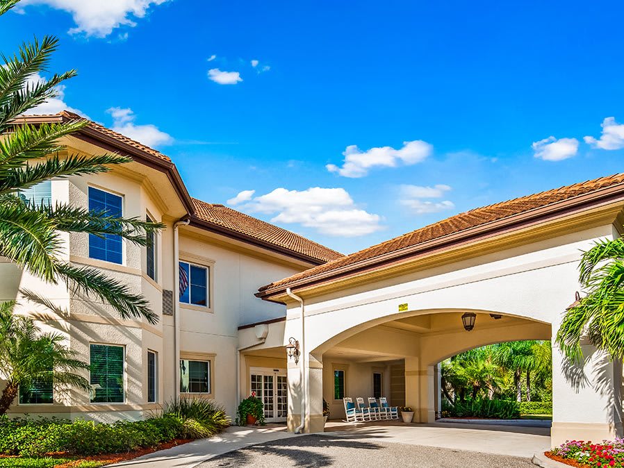 A hospital entrance with a covered driveway under a clear blue sky.