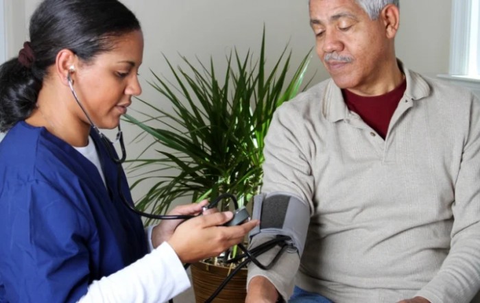 A healthcare professional measures a patient's blood pressure.