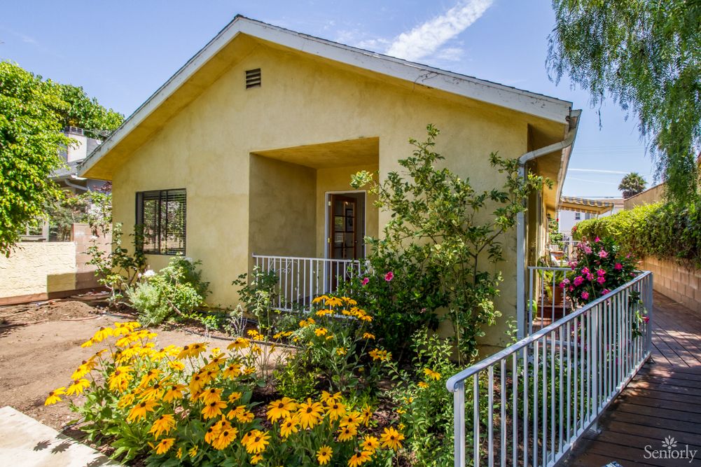 A charming house with a lush garden filled with vibrant flowers.