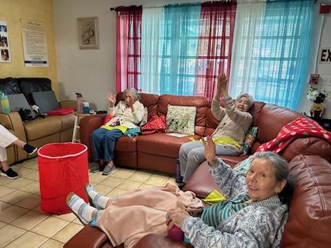 A cozy living room scene featuring a group of elderly individuals enjoying each other's company.