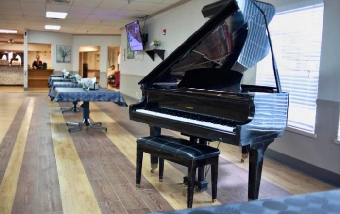 A grand piano with a bench in a room setting.