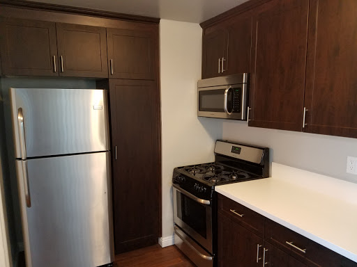 A modern kitchen featuring stainless steel appliances and dark wooden cabinets.