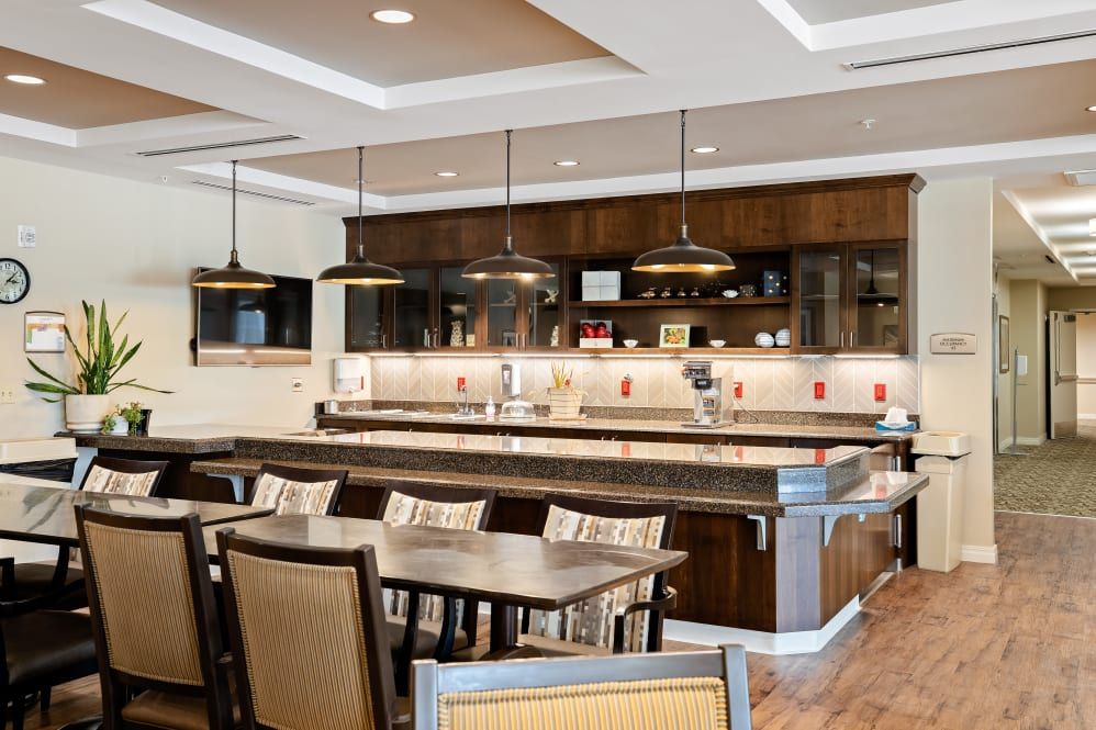 A modern kitchen and dining area with stylish lighting fixtures and comfortable seating.