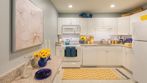 A bright and modern kitchen featuring white cabinetry, blue accents, and cheerful yellow decor.