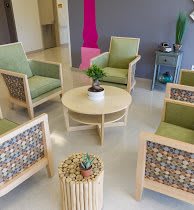 A modern waiting area with comfortable chairs and a central table featuring indoor plants.