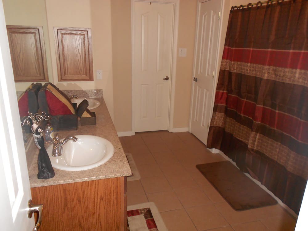 A clean bathroom with a sink, mirror, and a colorful shower curtain.