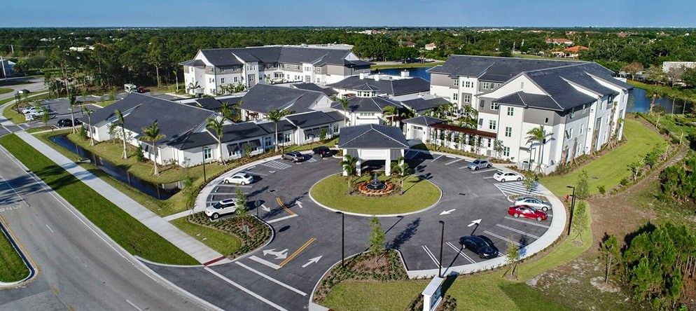 Aerial view of a modern residential complex with a circular driveway and landscaped surroundings.