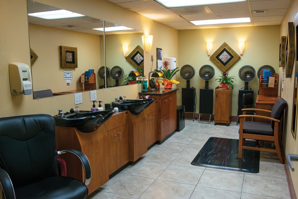 Interior view of a modern beauty salon with hair styling stations and equipment.