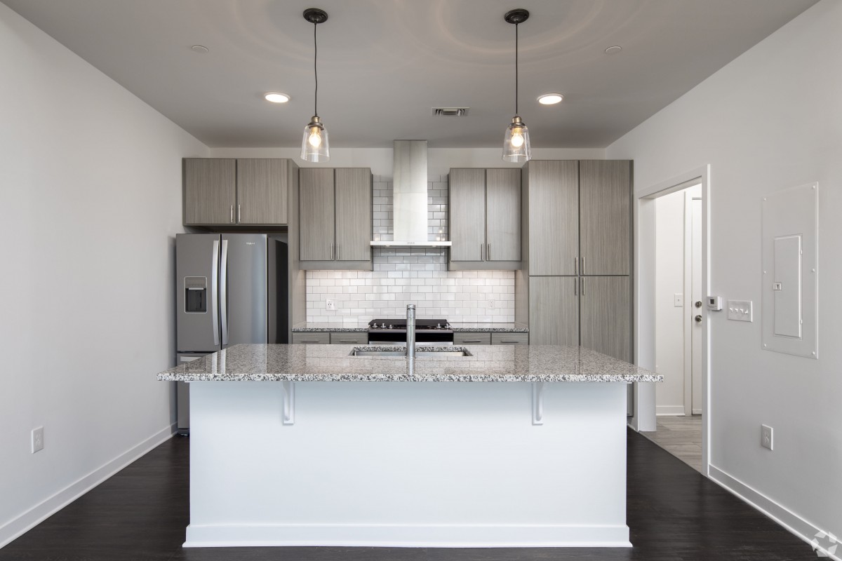 A modern kitchen with a central island and stainless steel appliances.