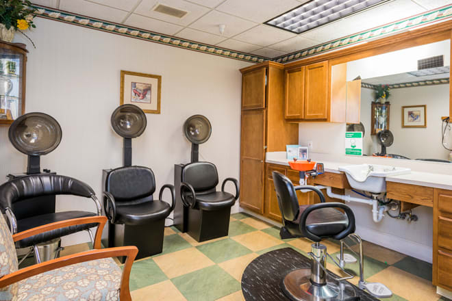 A cozy hair salon interior featuring styling stations and hair dryers.