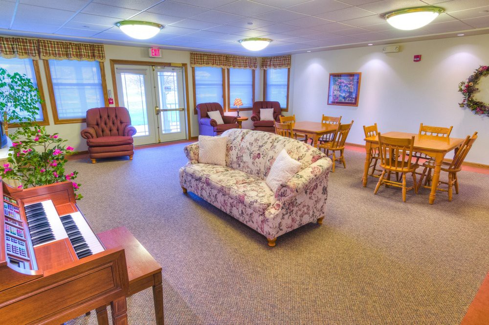 A cozy lounge area with a floral sofa, chairs, and tables.