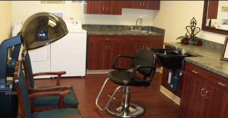 An interior of a hair salon with a styling chair and washing station.