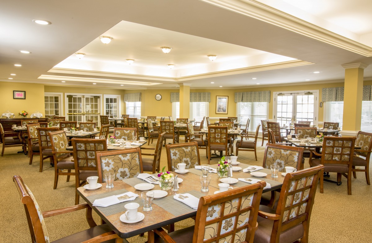 An elegant dining room setup with neatly arranged tables and chairs, ready for guests.