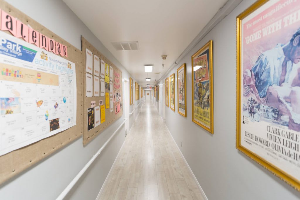A school hallway lined with posters and notice boards on both sides.