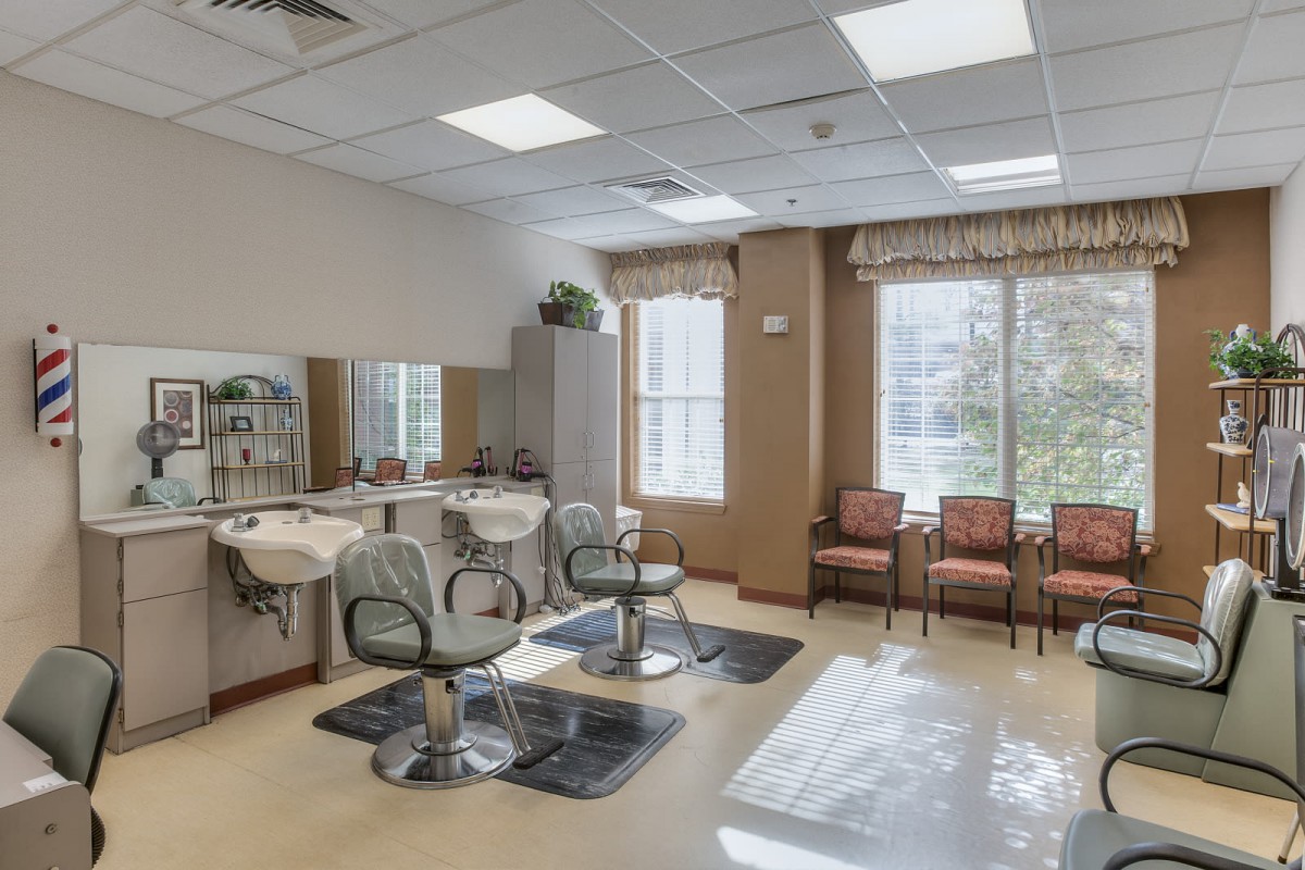 A bright and spacious hair salon with styling chairs and a cozy waiting area.