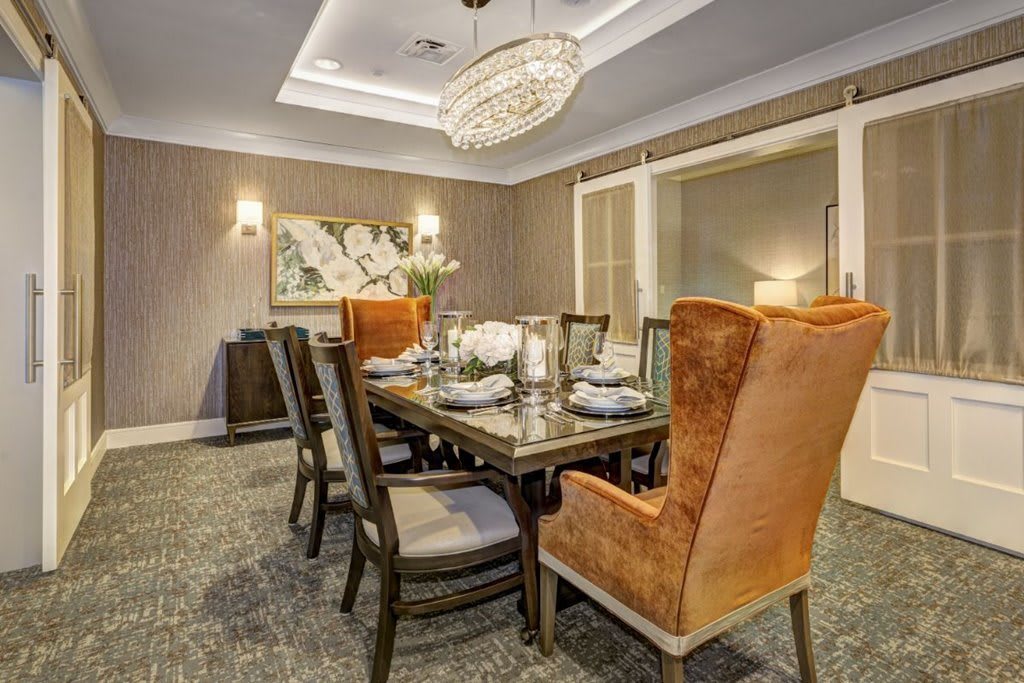 A modern dining room with elegant furnishings and a decorative chandelier.
