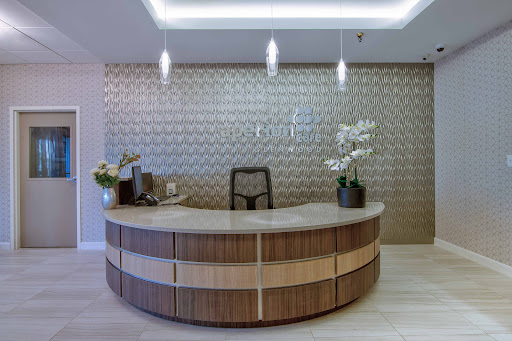 A modern reception area featuring an elegantly designed wooden front desk and stylish decor.
