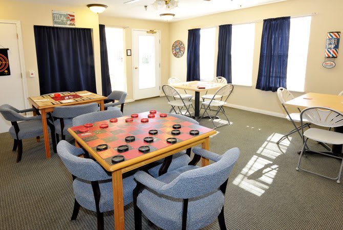 A cozy game room with a checkers board set up on the table.