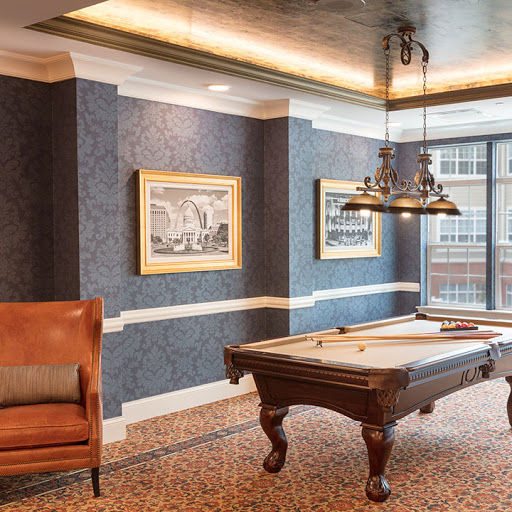 A stylish billiards room featuring a classic pool table, elegant decor, and framed artwork.