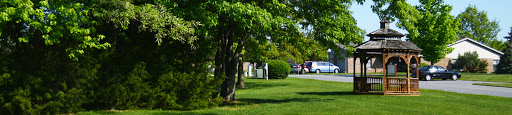 A peaceful outdoor scene featuring lush green trees and manicured grass.