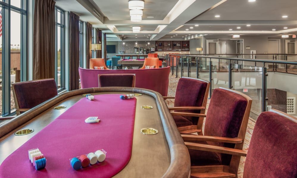 A luxurious casino gaming room featuring a poker table with playing cards and chips neatly arranged.