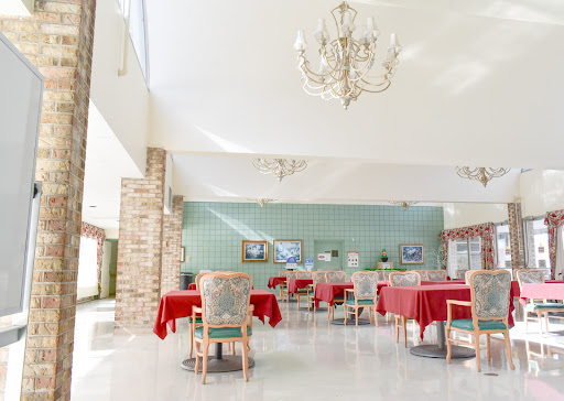 A bright and inviting dining area featuring red tablecloths and elegant chandeliers.