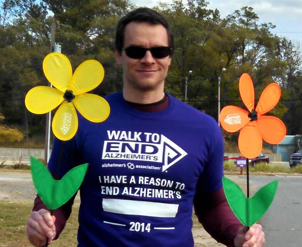 Individual participating in the Walk to End Alzheimer's, holding colorful flowers as a symbol of support and awareness.