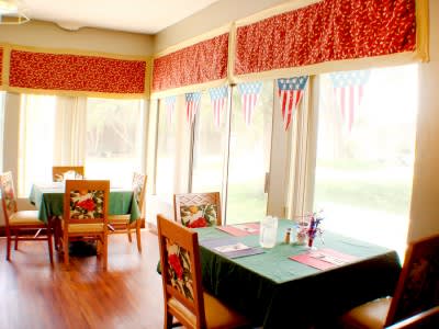 A cozy restaurant dining area with decorated tables and large windows letting in natural light.