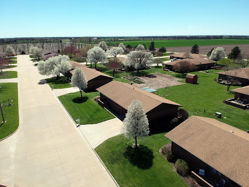 A serene aerial view of a residential area surrounded by lush greenery and blossoming trees in spring.