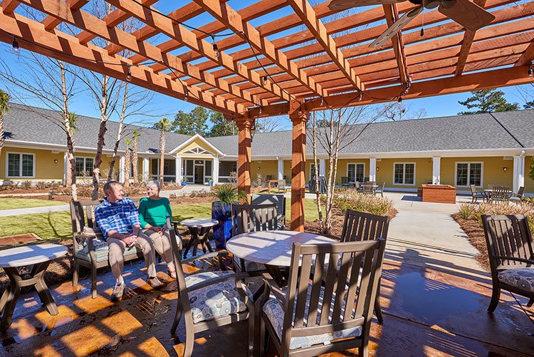 A cozy outdoor patio area with a wooden pergola and comfortable seating arrangements.