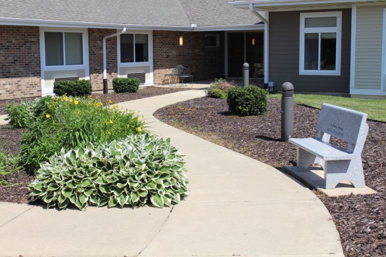 A landscaped garden pathway leading to a residential building entrance.