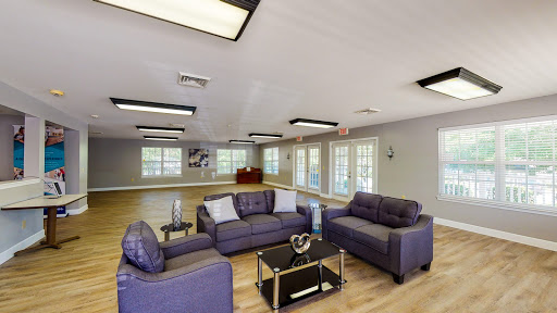 A modern living room featuring a cozy seating arrangement and ample natural light.