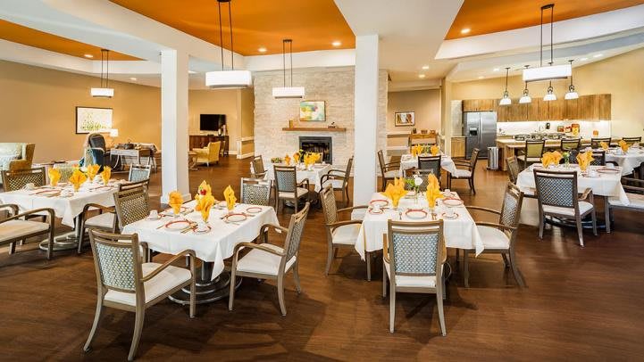 An elegant dining area with neatly arranged tables and chairs, featuring stylish lighting and decor.