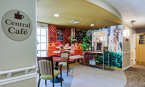 A cozy cafe-style interior with colorful wall art and comfortable seating.