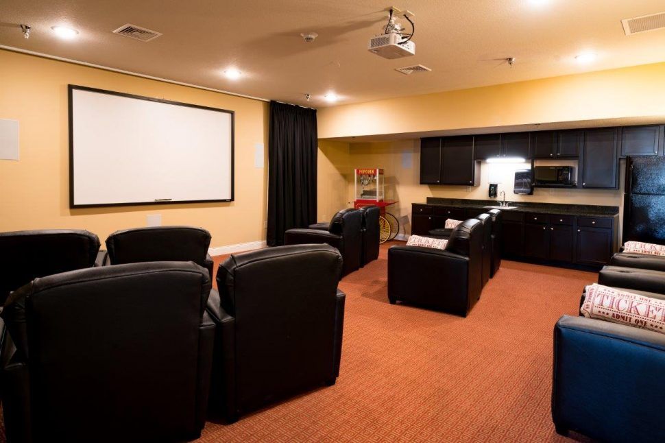 A cozy home theater setup with comfortable seating and a large projection screen.