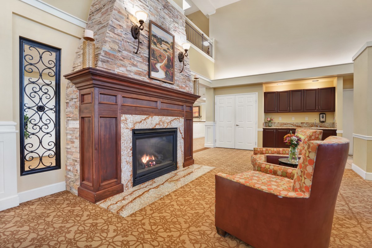 A cozy living room with a stone fireplace and comfortable seating.