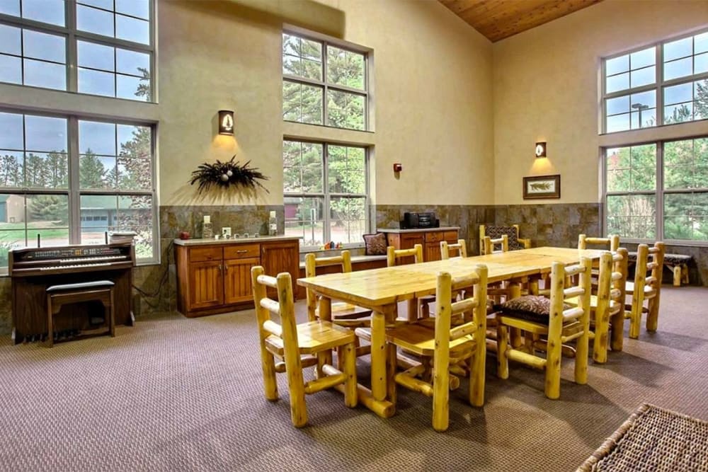 A cozy dining area featuring a wooden table and chairs with abundant natural light from large windows.
