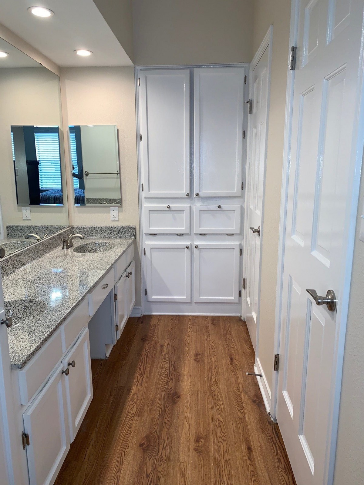 A modern bathroom with granite countertops and ample storage.