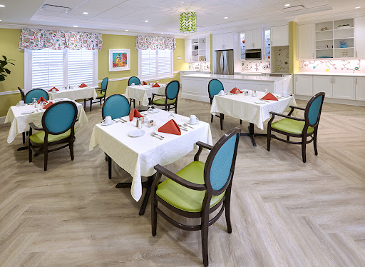 A bright and inviting dining area set up for a meal, featuring neatly arranged tables and colorful chairs.