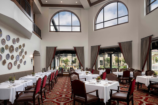 An elegant dining area featuring spacious tables and large windows that invite natural light.