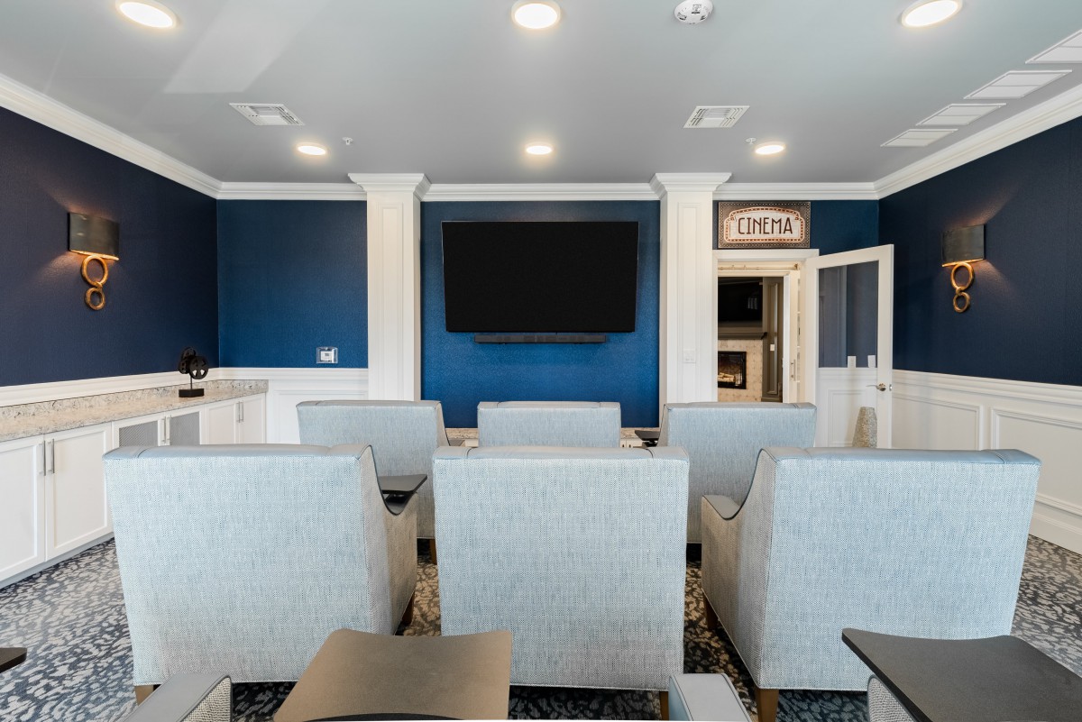 Modern theater room with comfortable seating and a large television.