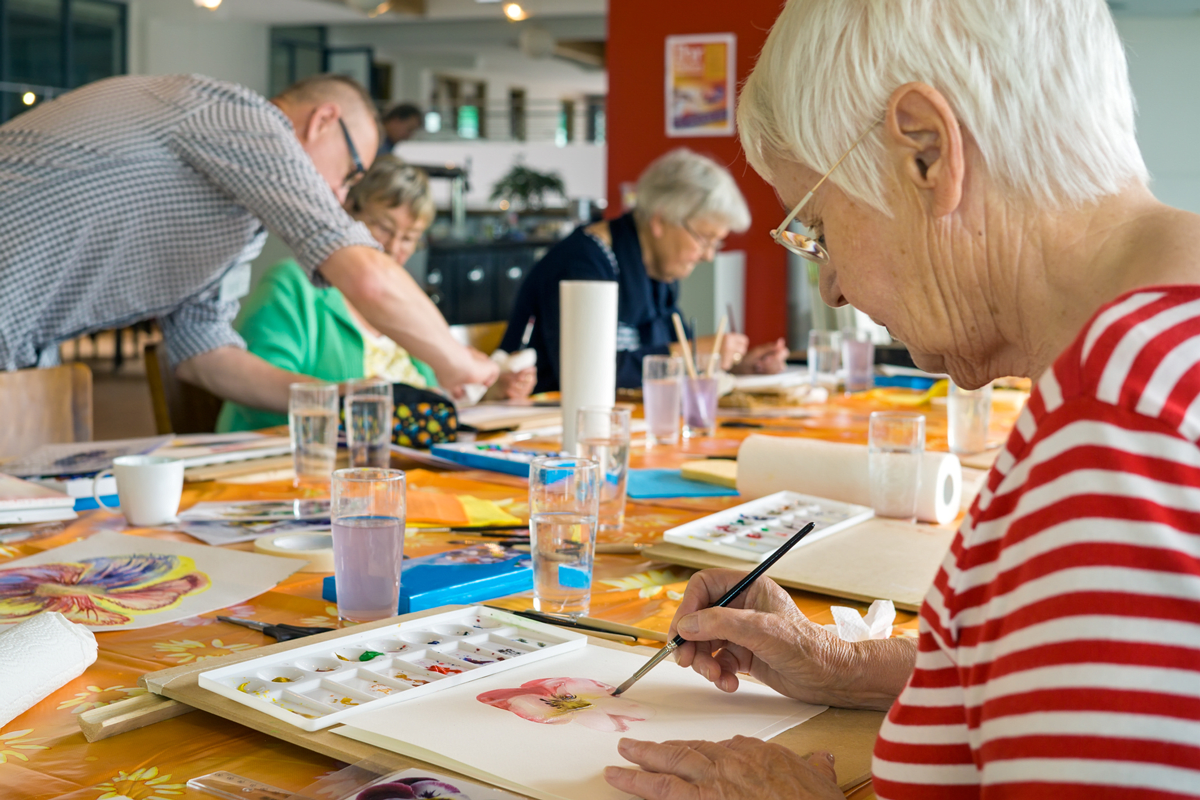 A group of elderly individuals engaging in a watercolor painting class.