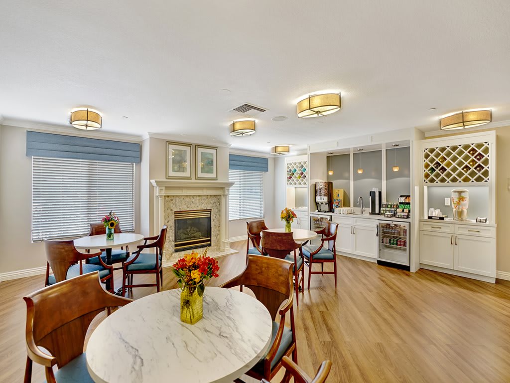 A modern and cozy dining area with a fireplace, featuring elegant tables and chairs.
