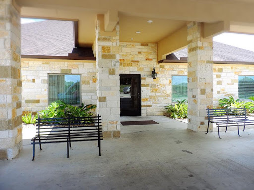 A welcoming entrance with stone architecture and benches for relaxation.