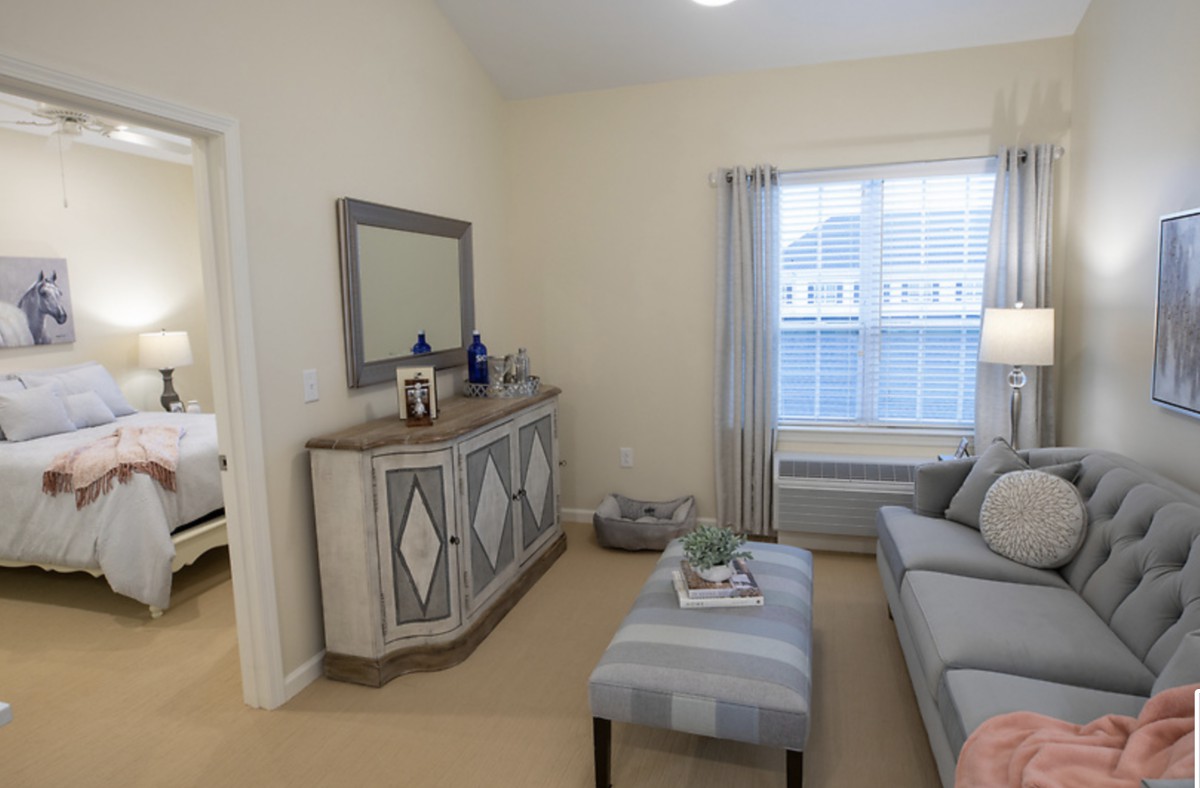 A cozy living room with a sofa, decorative mirror, and neutral tones.