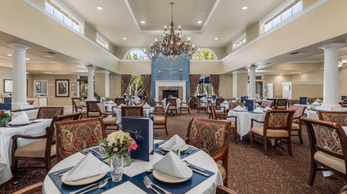 An elegantly decorated dining room with formal place settings and a chandelier.