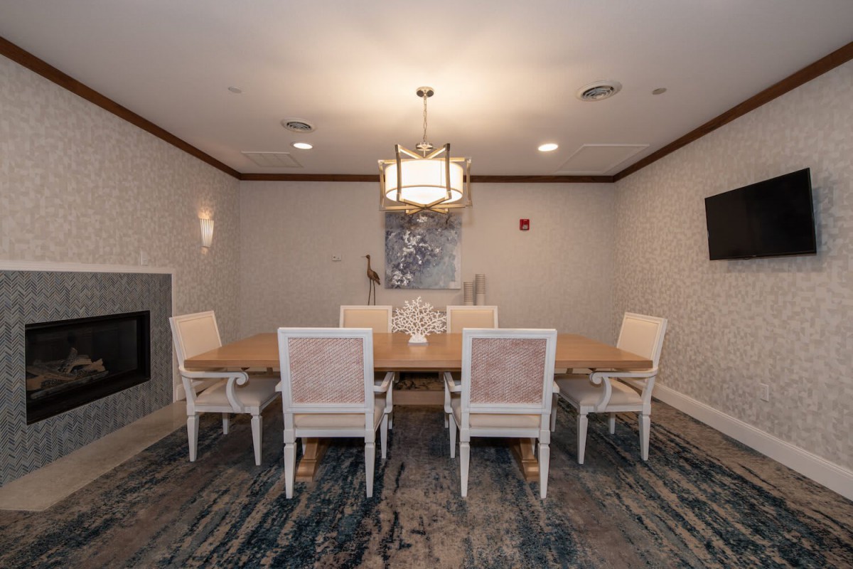 A modern dining room with a stylish table and chairs, illuminated by a chic chandelier.